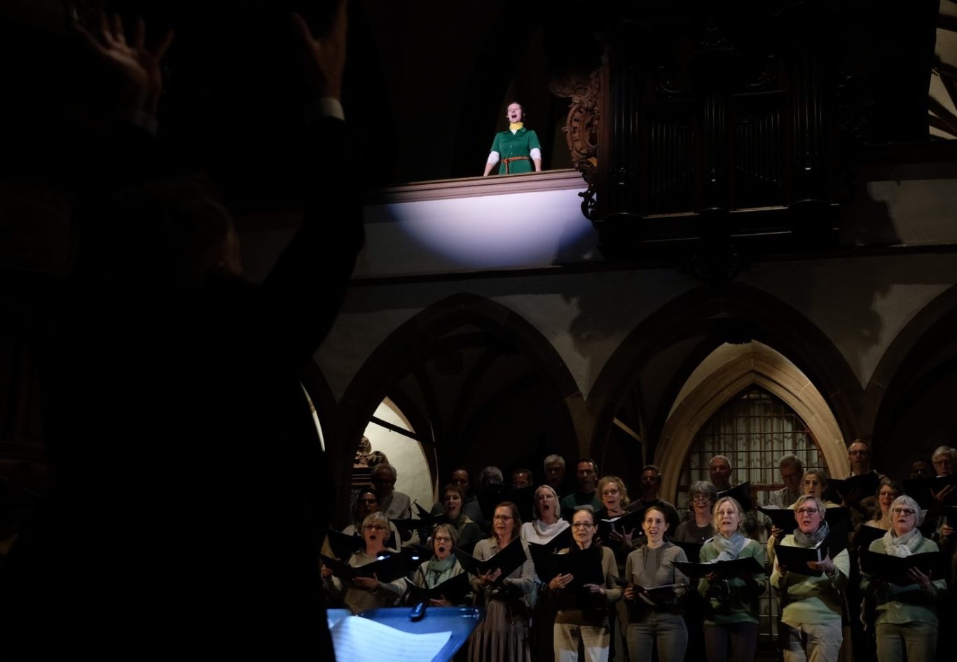 Finale Szene: Chor und Solistin in der Peterskirche, im Vordergrund der Dirigent