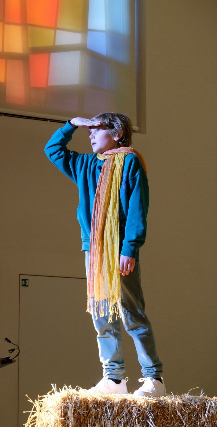 Der kleine Prinz steht auf einem Strohballen und hält Ausschau